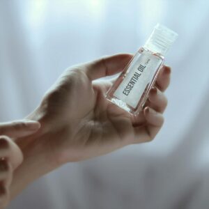Close-up of a hand holding an essential oil bottle, ideal for wellness and skincare concepts.